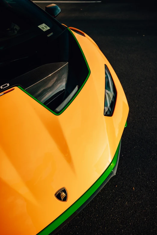 the front end of an orange sports car