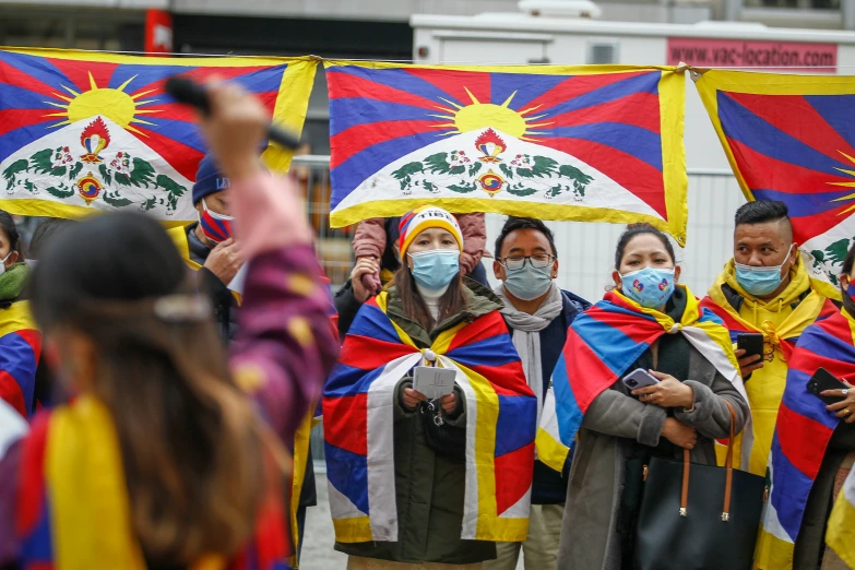 the people are wearing masks and holding flags