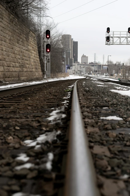 the railroad tracks is empty as a stoplight shines red