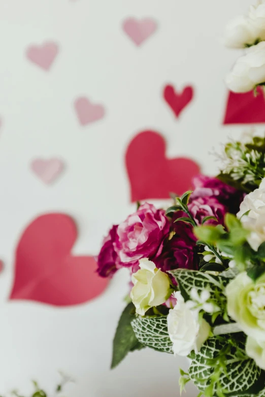 a vase of flowers in front of a valentine's heart wallpaper