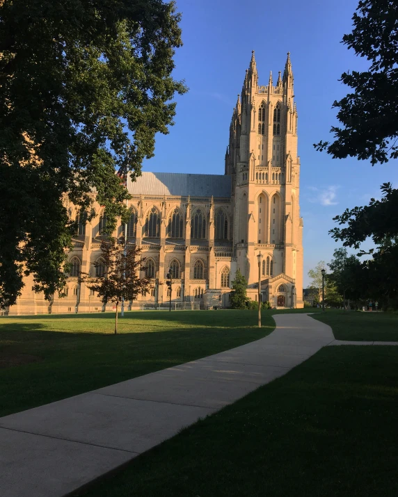 a large cathedral with a green lawn and a path in front