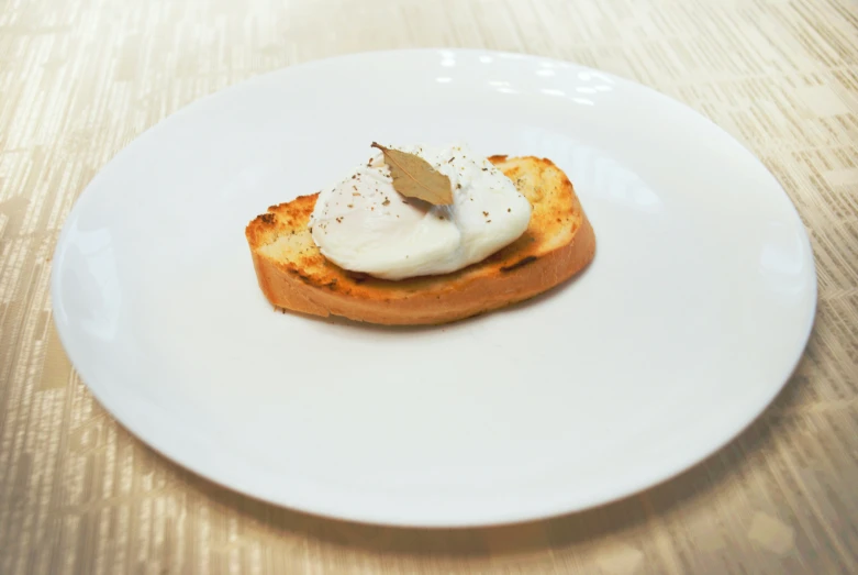 a white plate with toast topped with whipped cream