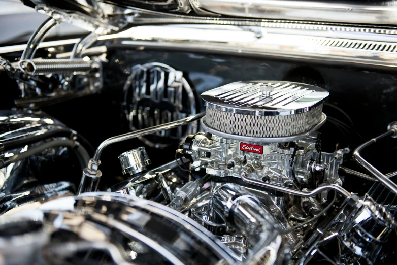 an old model silver engine and its chrome hood