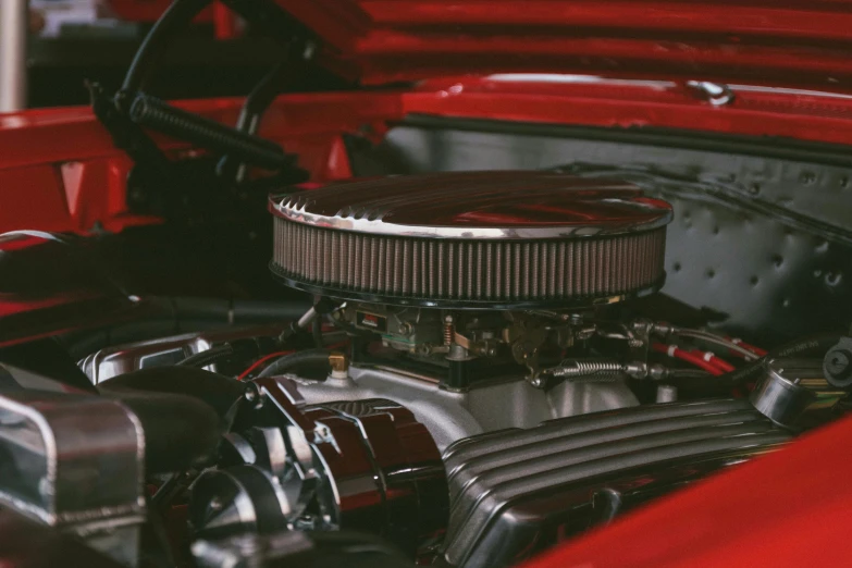 engine view of an orange car in a showroom