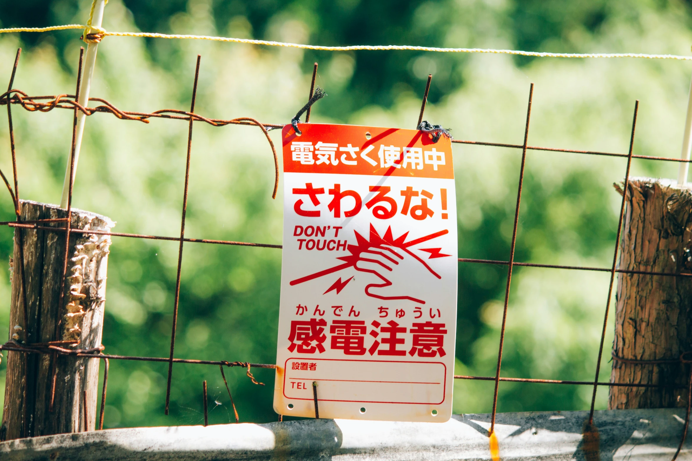 a sign near the fence has words written in chinese