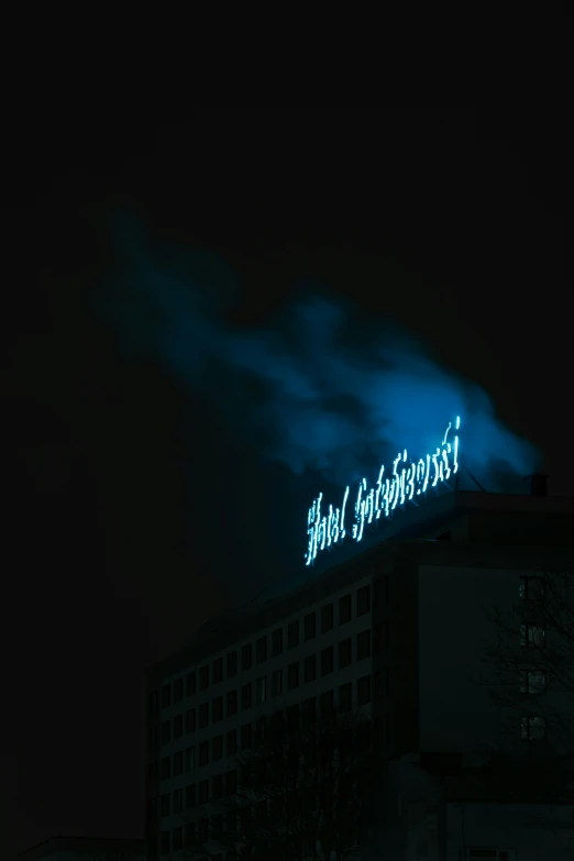 a large building with green lights in the night sky