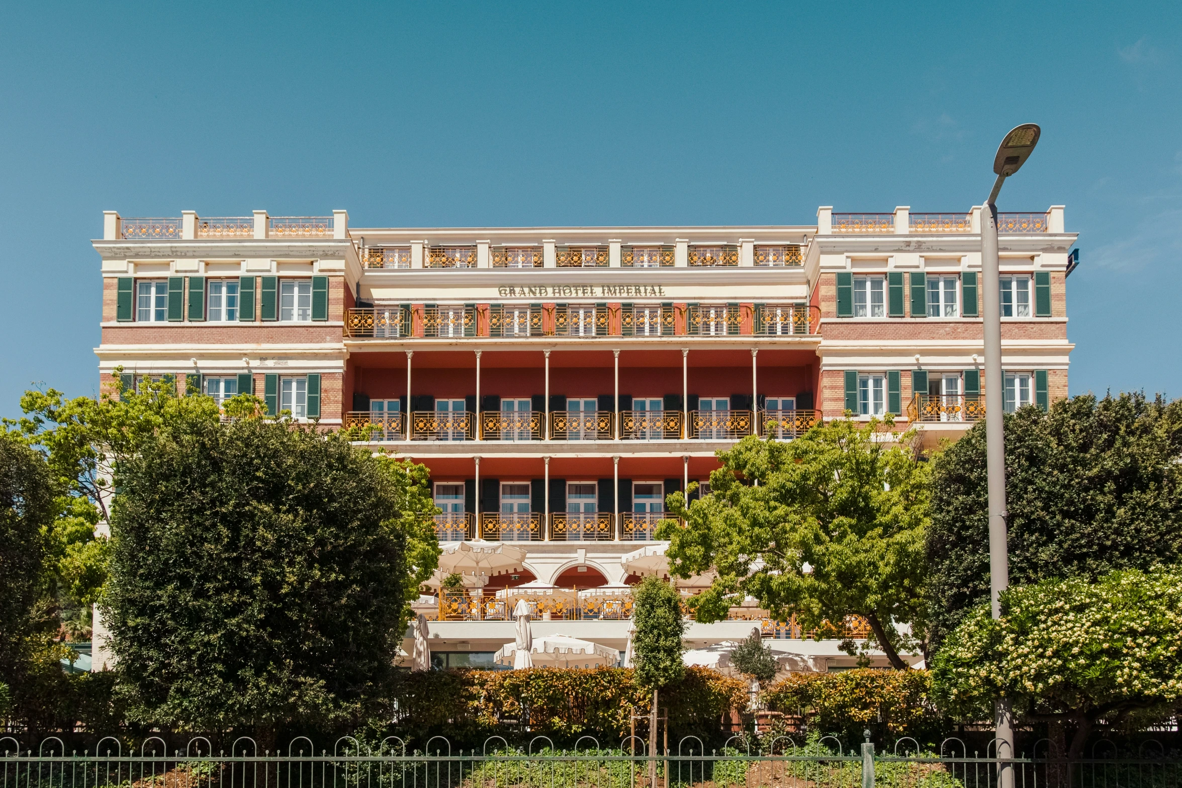 the large building is brick and white with a balcony