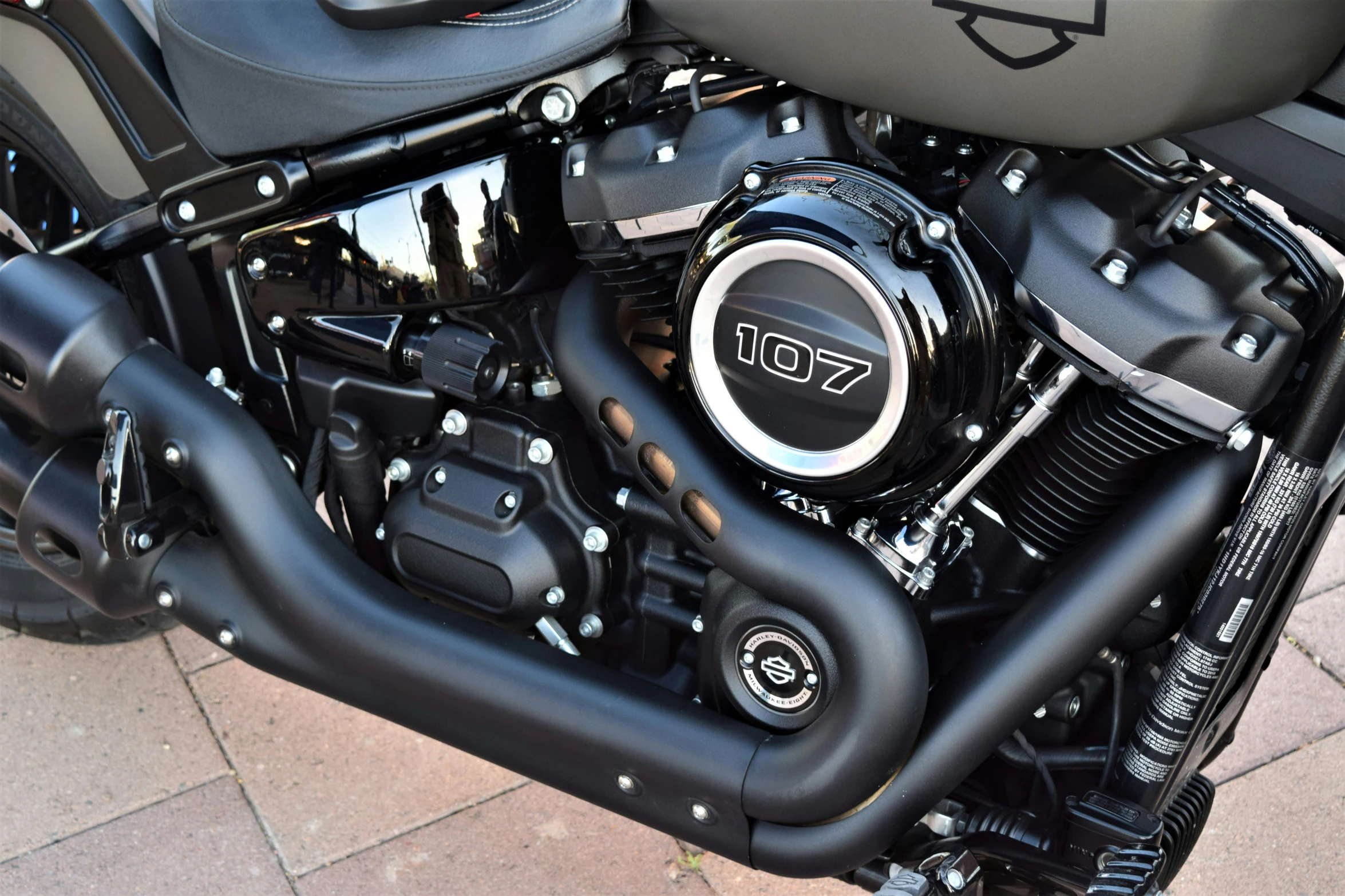 a motorcycle engine and seat on a paved street