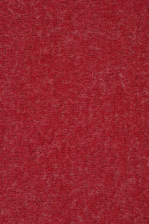 a dark red rug with small gray patches on it