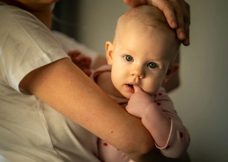 a woman holding a small baby in her lap