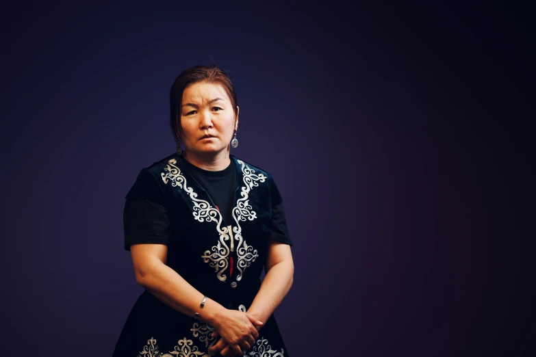 woman dressed in black standing in front of dark background