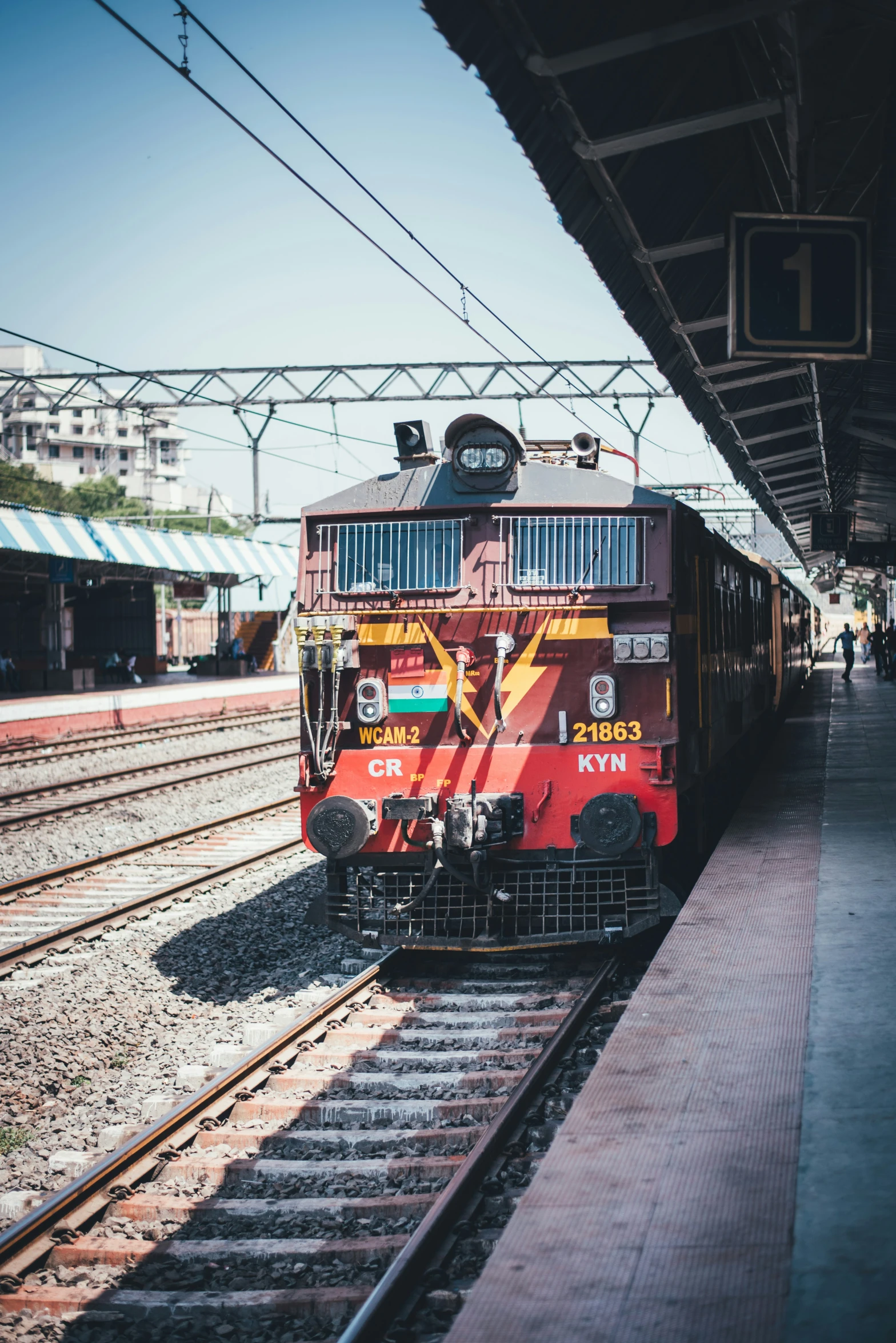 an orange and red train engine pulling carts behind it