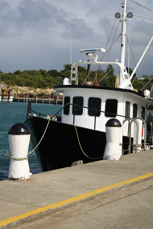 a large boat docked on a small pier