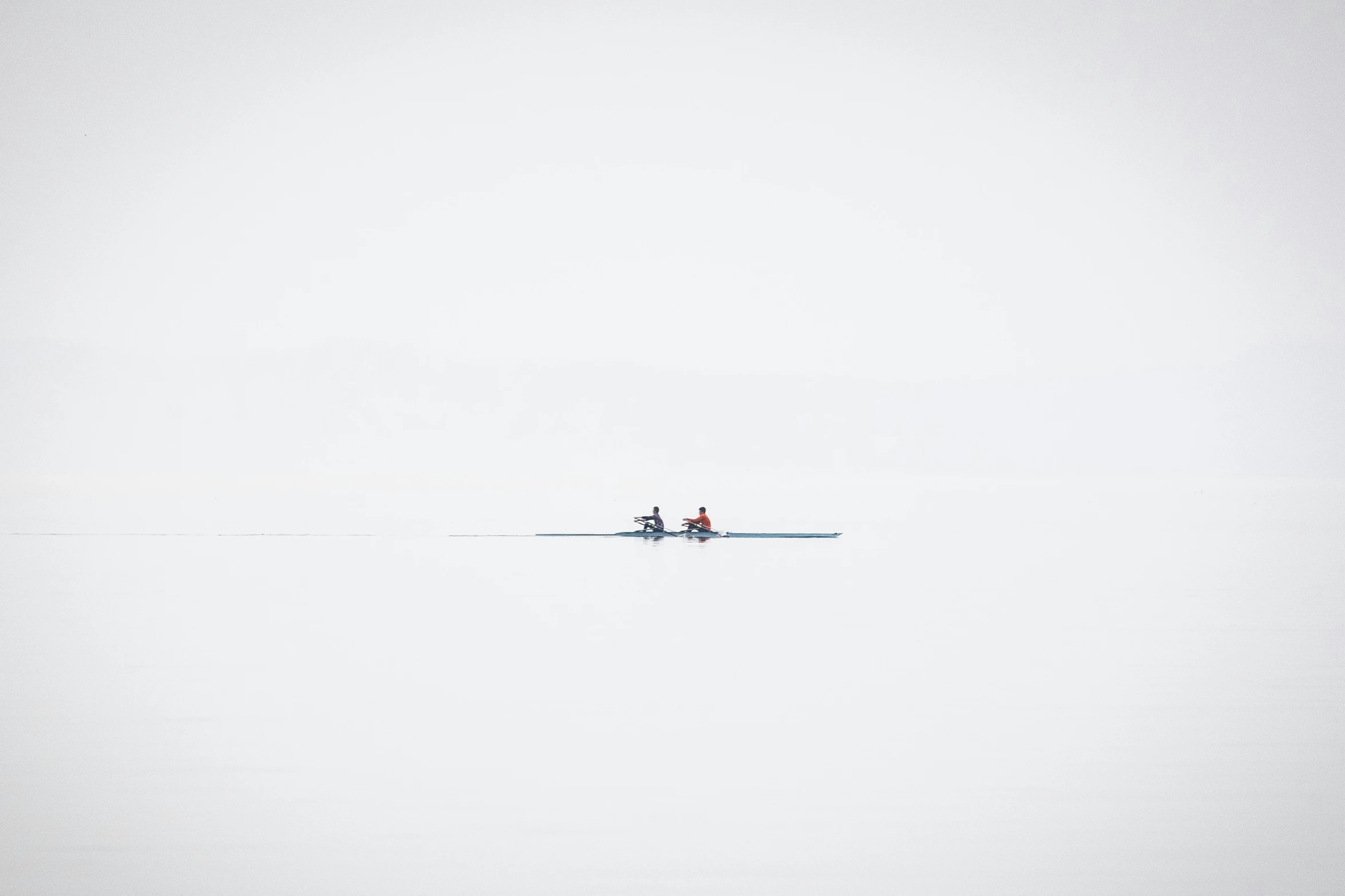 two people in water skis are standing near the shore