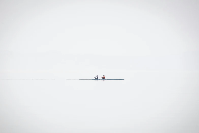 two people in water skis are standing near the shore