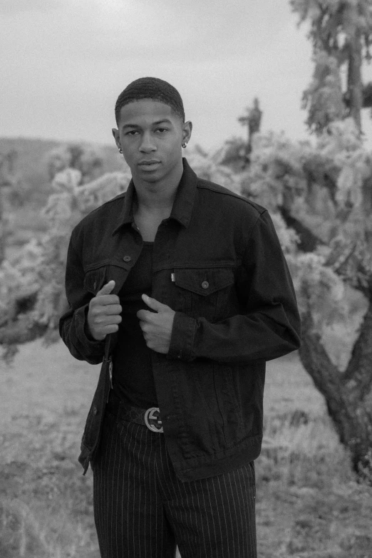 a man in a field standing wearing striped pants