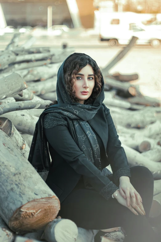 a woman sitting on logs in a black shirt