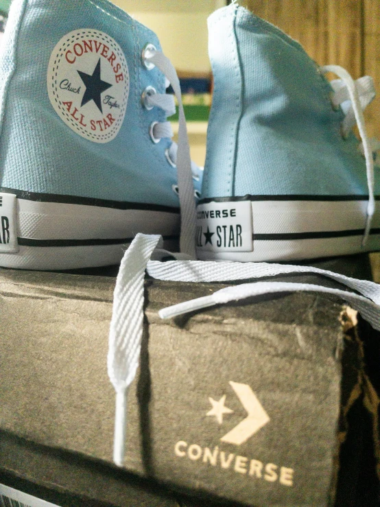 two blue converse sneakers on top of a book