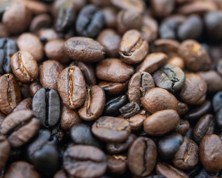 some brown coffee beans stacked together with each other