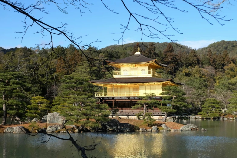 a building on the top of a hill with trees in front of it