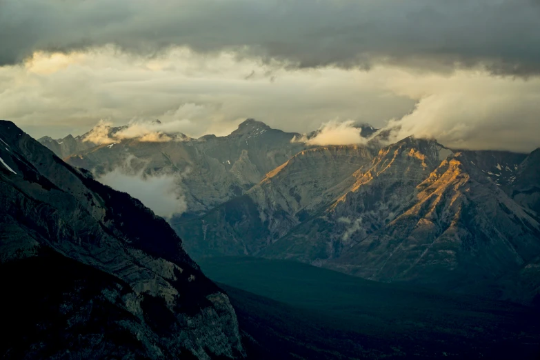 some snow and brown mountains under a cloudy sky