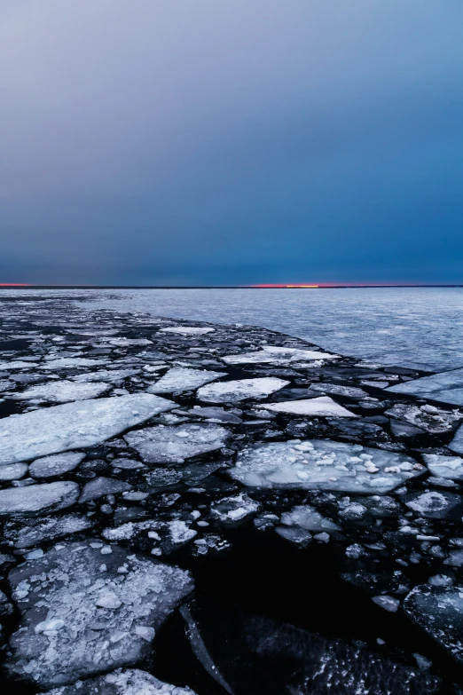 an ocean with ice and land in the background