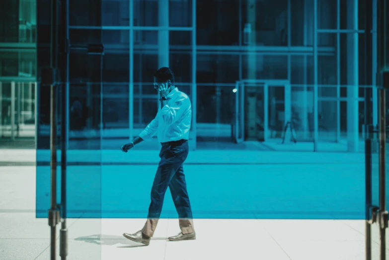 the man wearing a blue jacket is walking outside of a building