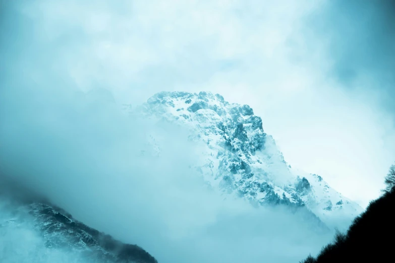 a large mountain surrounded by cloud in the distance