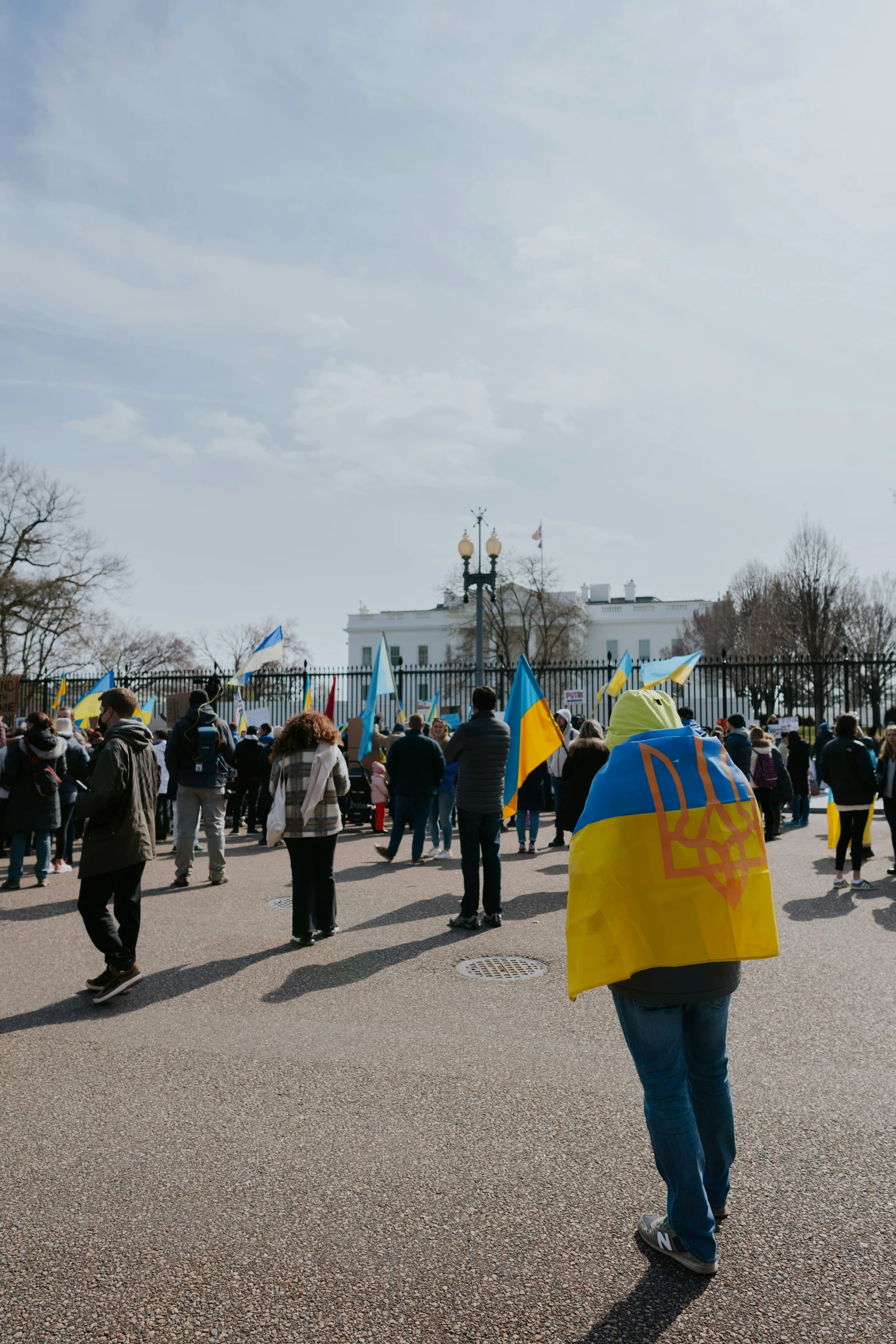 a group of people walking through a parking lot with flags