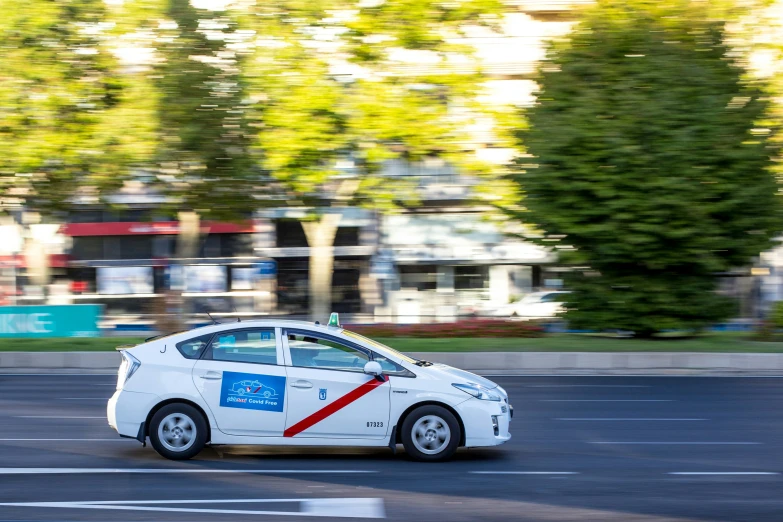 a car with a sticker on it driving down the road