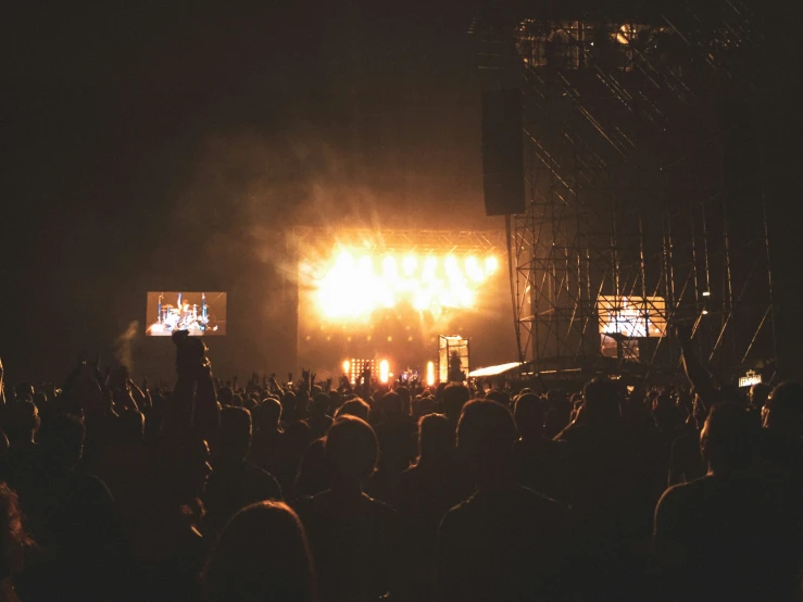 an outdoor concert stage at night with a lit up audience