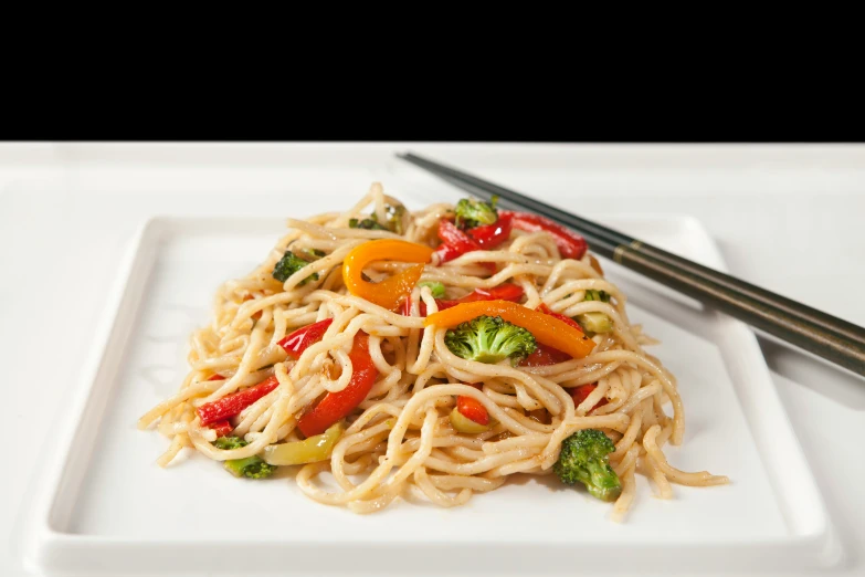 a plate with a noodles, broccoli and peppers