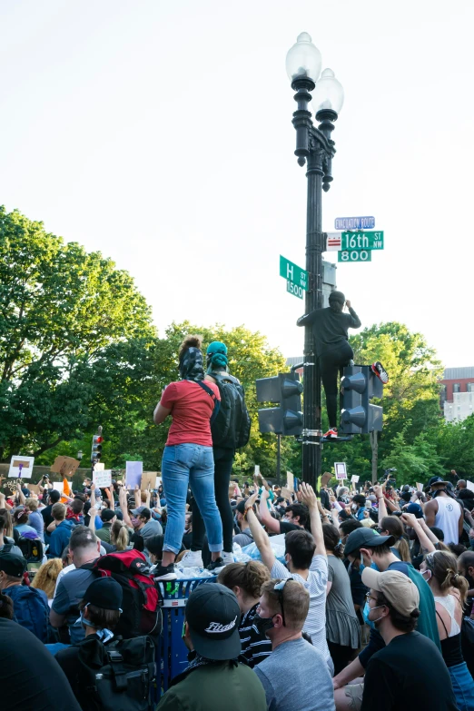 many people are gathered around a street light