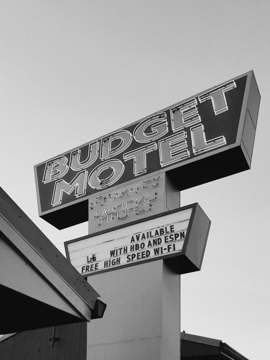 a sign is hanging off of the roof of a building