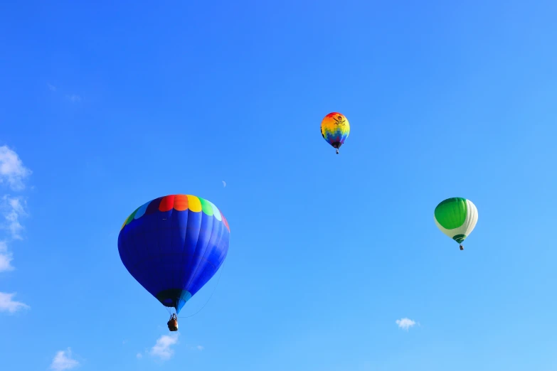 a few different color  air balloons in the blue sky