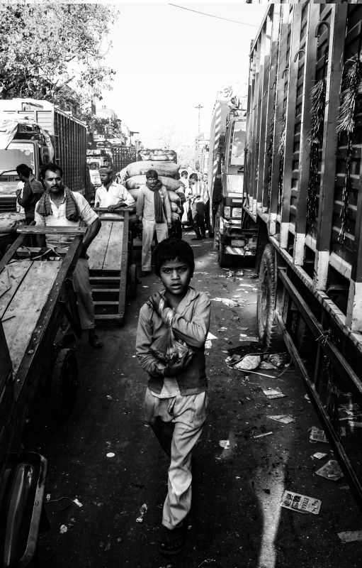 a young child walking on a street by some vehicles