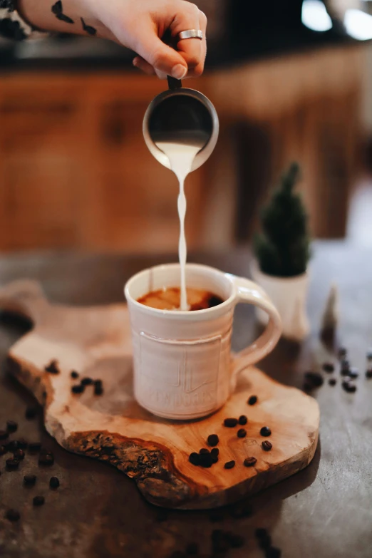 a person is pouring some liquid into a mug