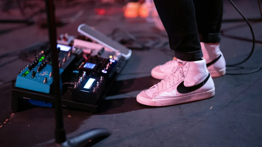 a pair of sneakers is on the stage next to some electronic equipment