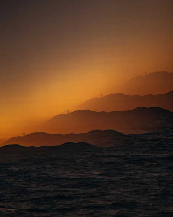 a plane flying high over the ocean at sunset