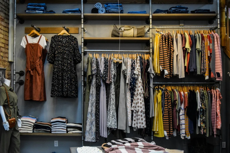 a clothing shop with shirts on racks and clothes hanging up