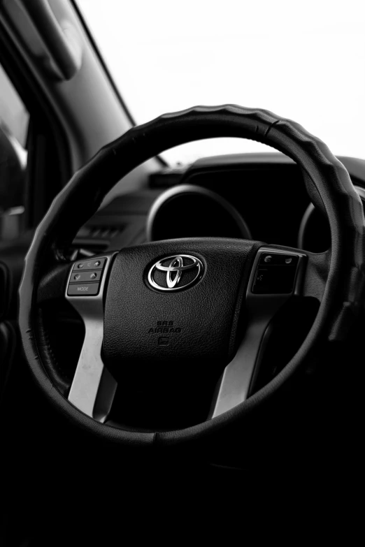 steering wheel of a car in front of the open door window