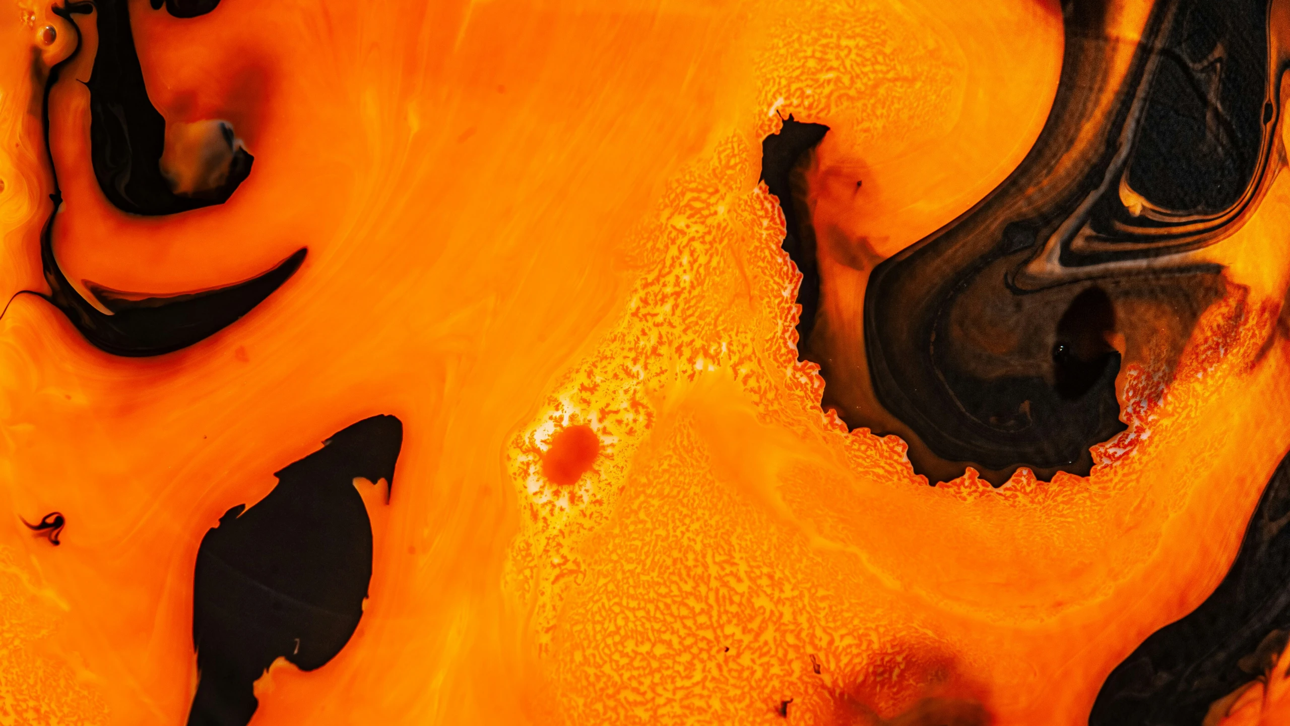 a liquid pouring out of a pot with orange and black designs