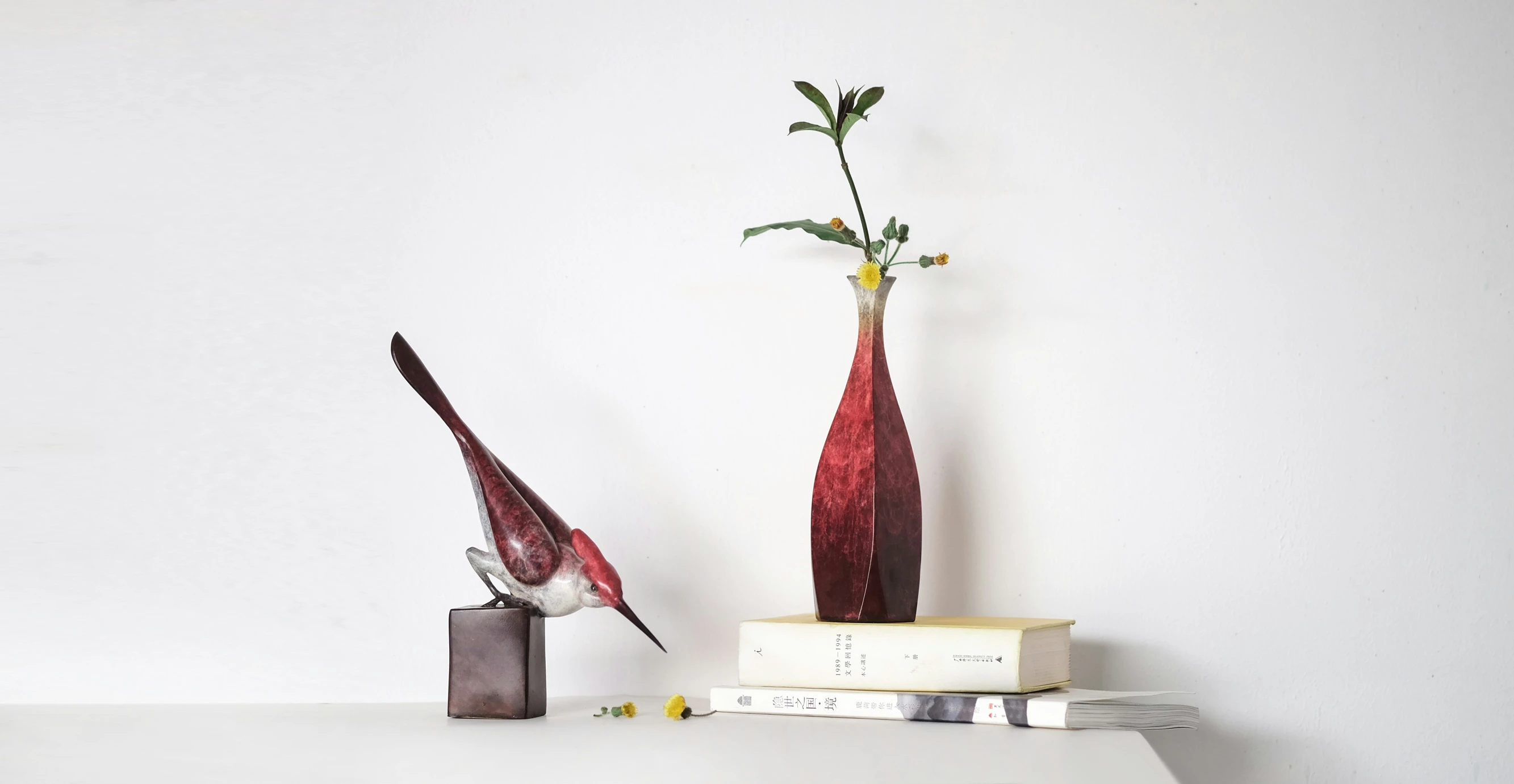 a vase with flowers sitting on top of books