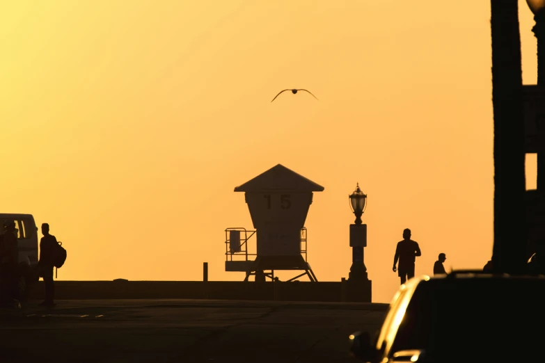 a person walking on a city street with a lifeguard tower