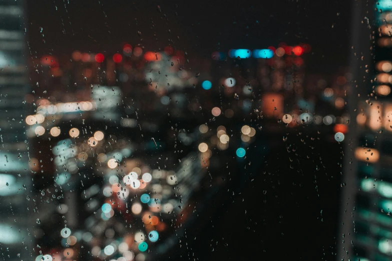 a blurry city at night as seen from a rain covered window
