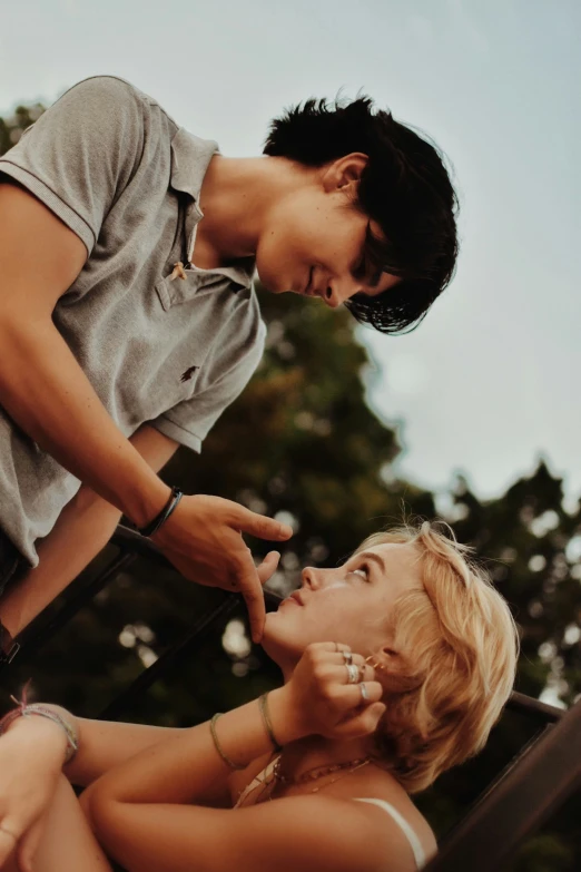 a woman is combing another women hair outdoors