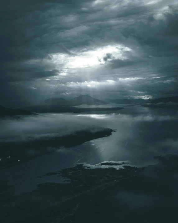 clouds are reflected in water below a cloudy sky