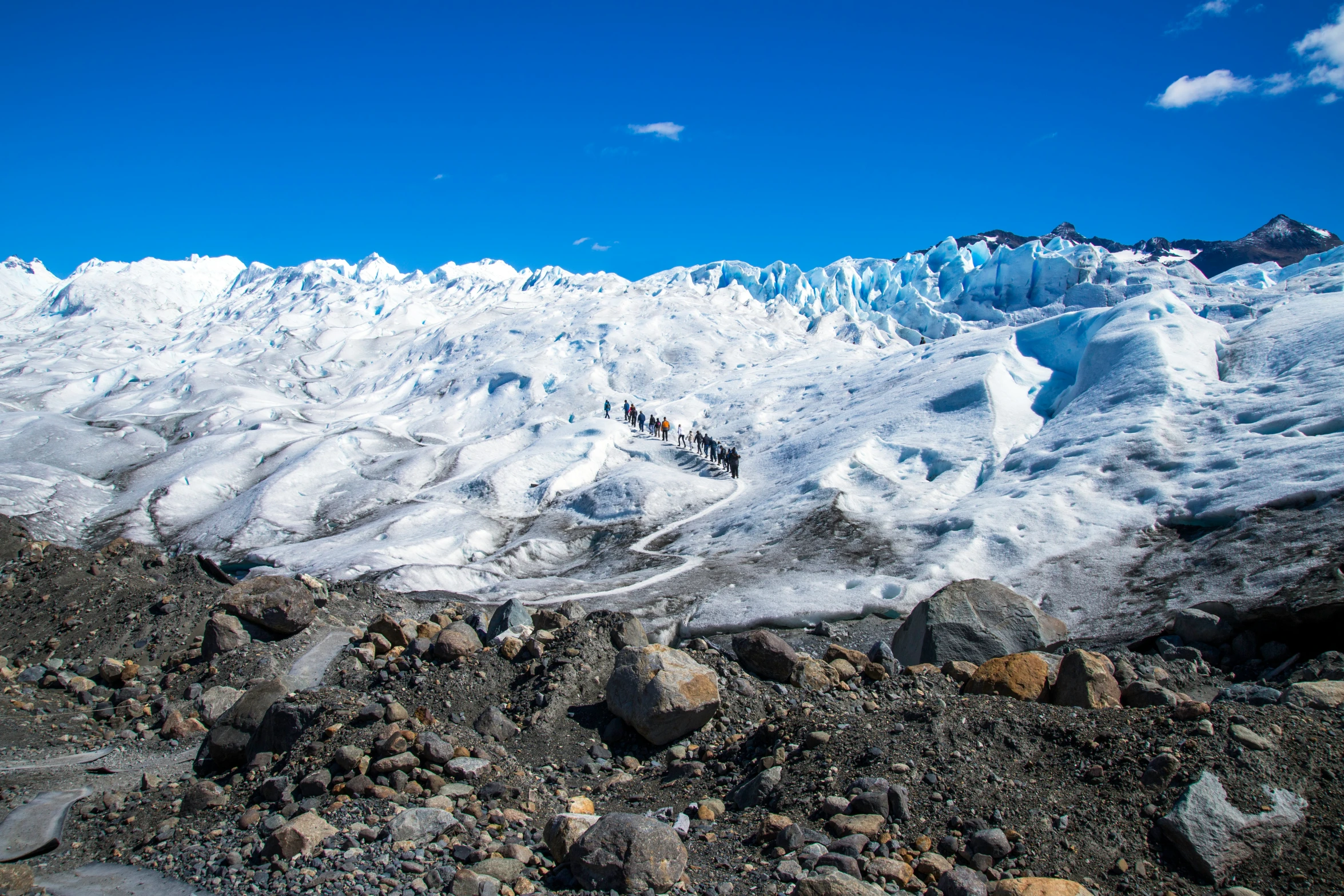 a very snowy mountain with mountains and a sky background