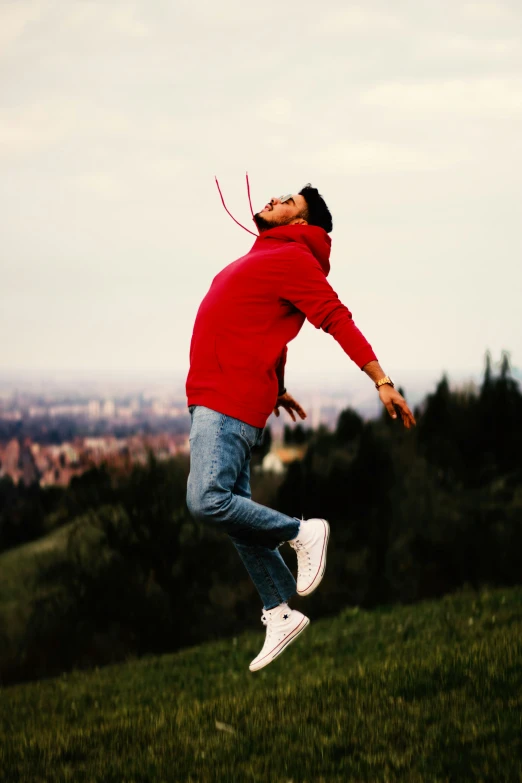 a young man is jumping in the air to catch a kite