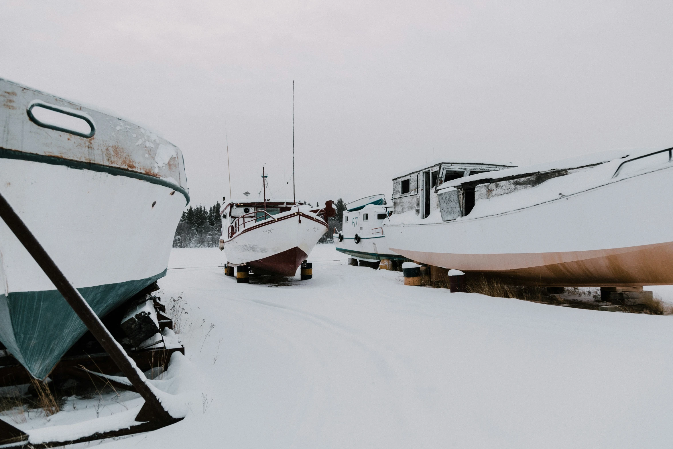 snow covered boats next to docks in the ocean